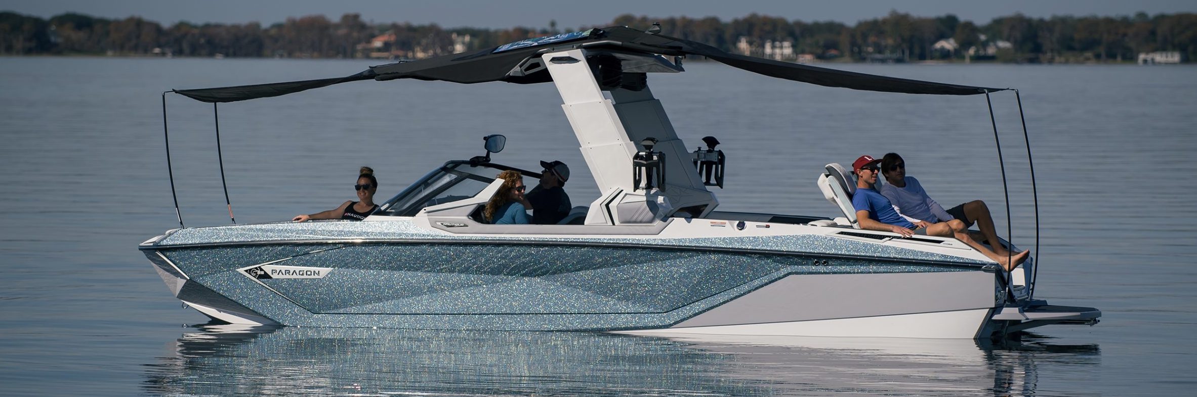 People lounging under a canopy on a Chaparral boat out on the lake